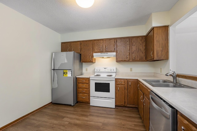 kitchen featuring sink, stainless steel appliances, dark hardwood / wood-style floors, and a textured ceiling