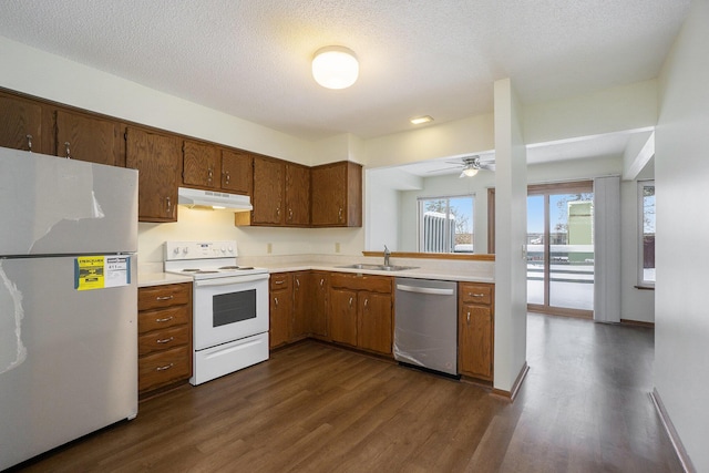 kitchen featuring sink, dark wood-type flooring, dishwasher, refrigerator, and electric range