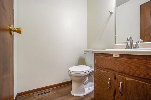 bathroom with vanity, hardwood / wood-style floors, and toilet