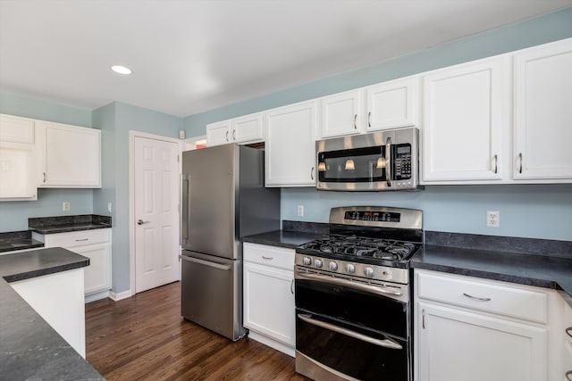 kitchen with white cabinetry, appliances with stainless steel finishes, and dark hardwood / wood-style floors