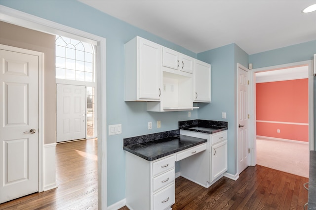 kitchen featuring white cabinetry, dark hardwood / wood-style floors, and built in desk