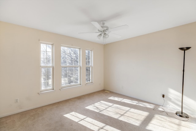 carpeted spare room with ceiling fan