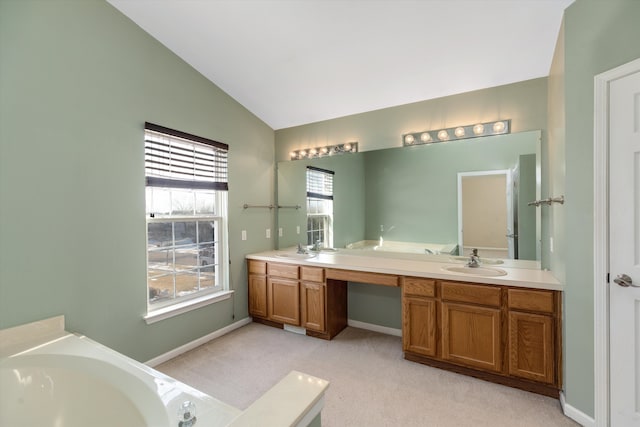 bathroom with vanity, lofted ceiling, and a tub