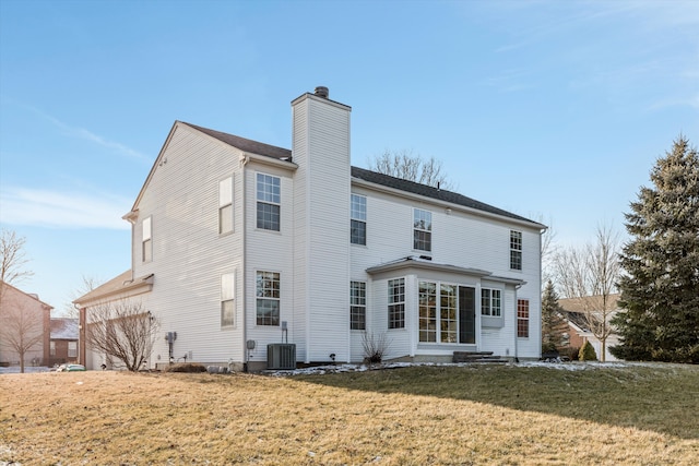 rear view of property with a yard and central air condition unit