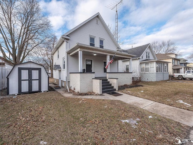 view of front of house featuring a storage shed, a front lawn, and covered porch