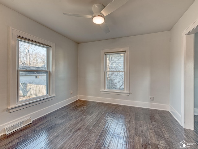 spare room with plenty of natural light, dark hardwood / wood-style floors, and ceiling fan