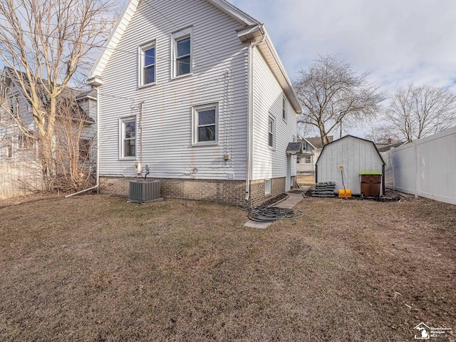 rear view of house featuring a yard and central air condition unit