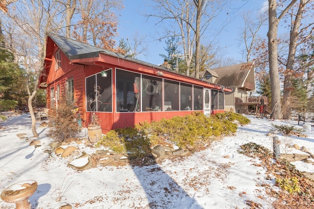 snow covered property featuring a sunroom