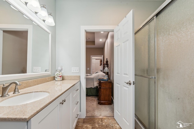 bathroom featuring a shower with door and vanity