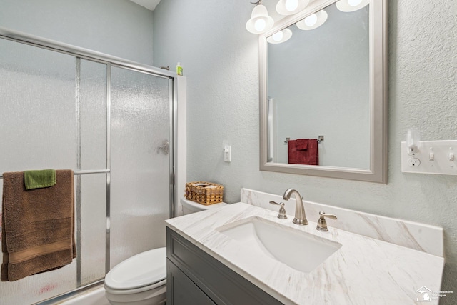 bathroom with walk in shower, vanity, and toilet