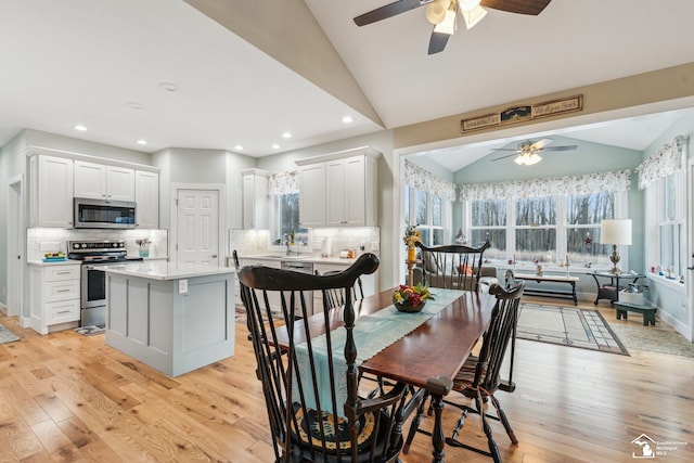 dining space featuring lofted ceiling and light wood-type flooring