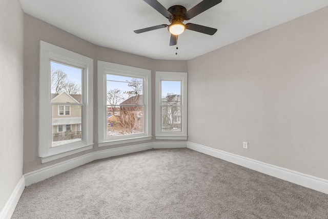 carpeted spare room with ceiling fan