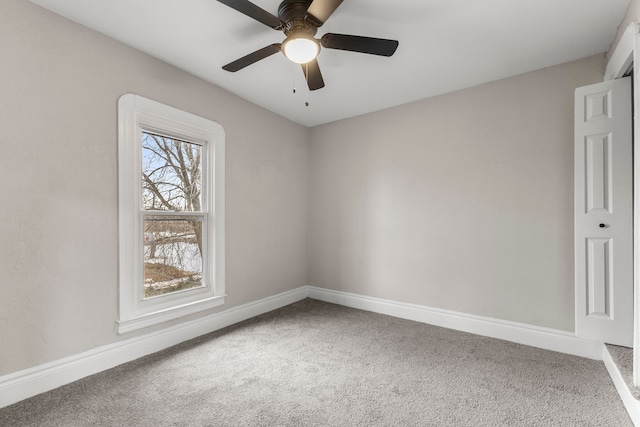 carpeted spare room featuring ceiling fan