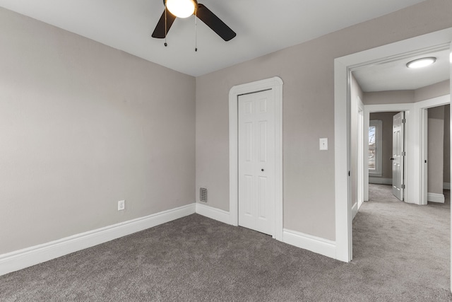 unfurnished bedroom featuring carpet, ceiling fan, and a closet