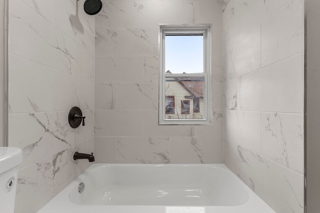 bathroom featuring tiled shower / bath and toilet