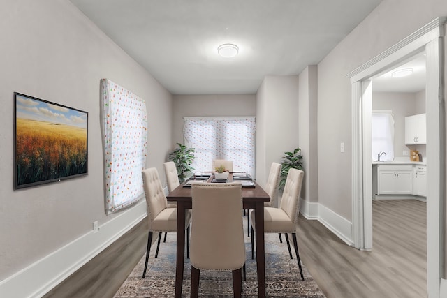 dining space with dark hardwood / wood-style flooring, sink, and plenty of natural light