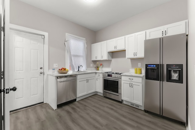 kitchen featuring dark hardwood / wood-style flooring, sink, stainless steel appliances, and white cabinets