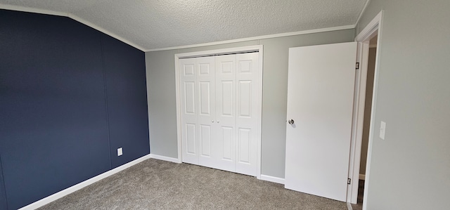 unfurnished bedroom with lofted ceiling, a closet, a textured ceiling, and carpet