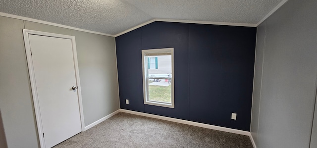 unfurnished bedroom with vaulted ceiling, ornamental molding, a textured ceiling, and carpet