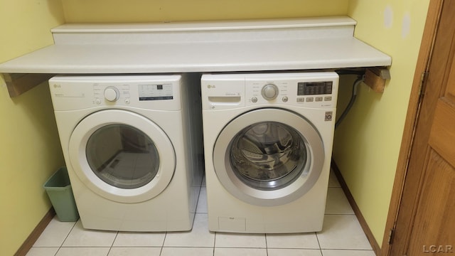 washroom featuring washing machine and dryer and light tile patterned flooring