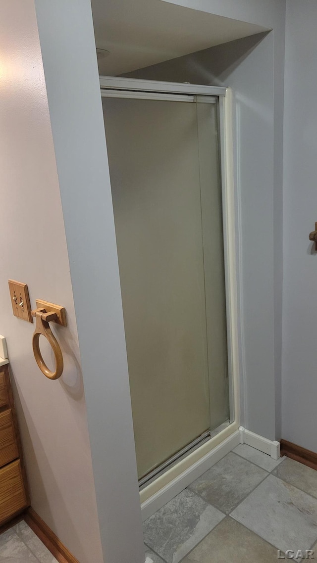 bathroom featuring vanity and a shower with door