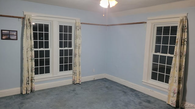 spare room featuring dark colored carpet