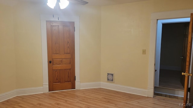 spare room with ceiling fan and light wood-type flooring