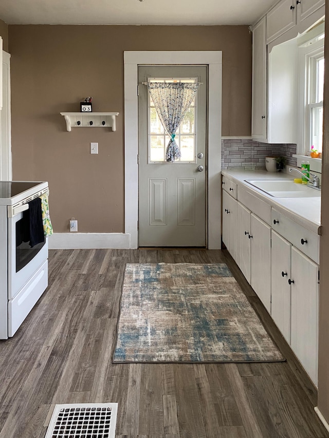 kitchen featuring sink, dark wood-type flooring, white cabinets, and electric stove