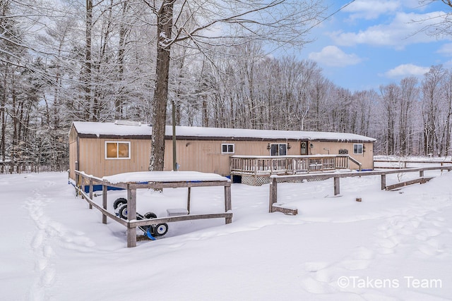 snow covered house featuring a deck