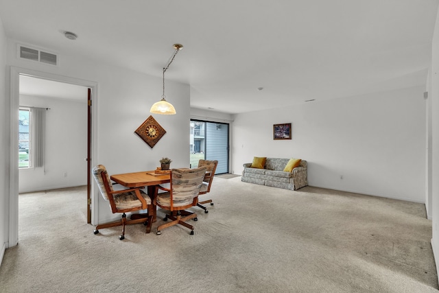 carpeted dining space with a healthy amount of sunlight