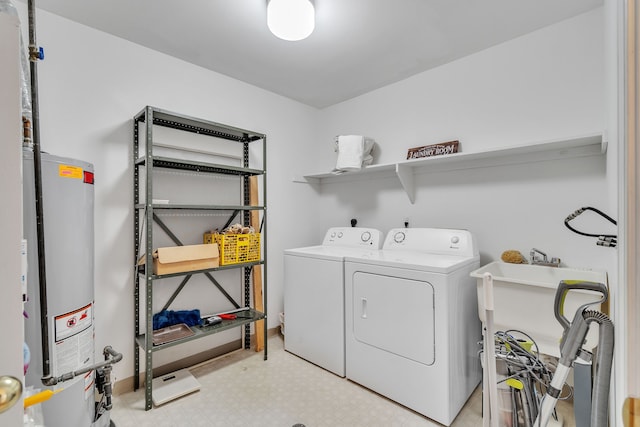 clothes washing area with gas water heater and washer and dryer