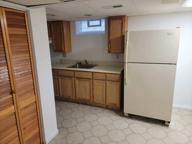 kitchen with fridge, sink, and a drop ceiling