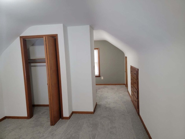 bonus room with lofted ceiling and light carpet