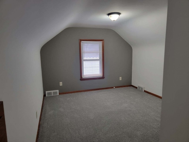 additional living space featuring lofted ceiling and carpet flooring