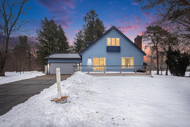 snow covered property featuring a garage