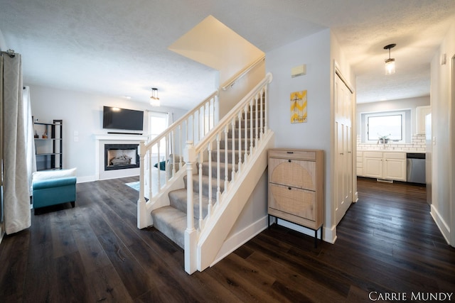 staircase with hardwood / wood-style floors and a textured ceiling