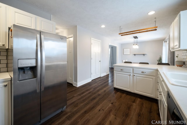 kitchen featuring dark hardwood / wood-style floors, stainless steel fridge with ice dispenser, white cabinets, hanging light fixtures, and kitchen peninsula