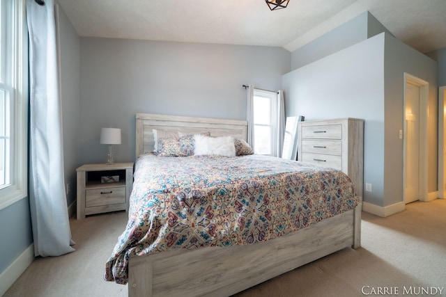 bedroom with lofted ceiling and light colored carpet