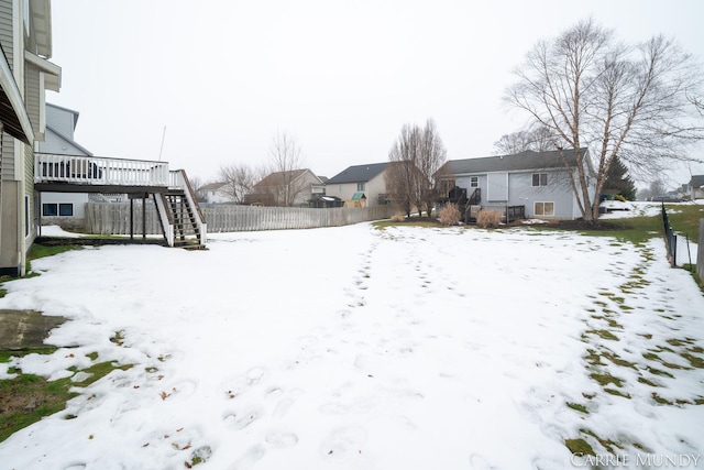 yard covered in snow with a wooden deck