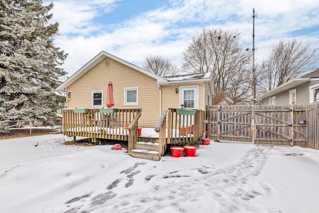 snow covered house featuring a deck