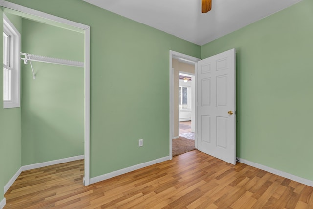 unfurnished bedroom featuring a closet, ceiling fan, and light hardwood / wood-style flooring