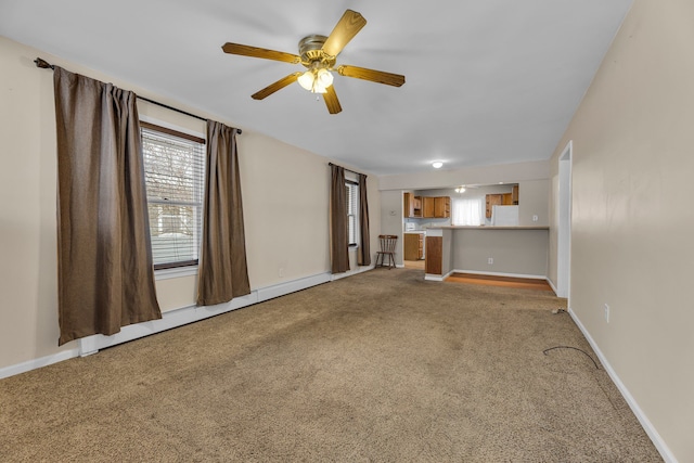 unfurnished living room with light carpet, a baseboard radiator, and ceiling fan