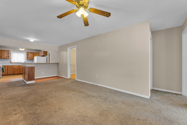 unfurnished living room with light carpet and ceiling fan