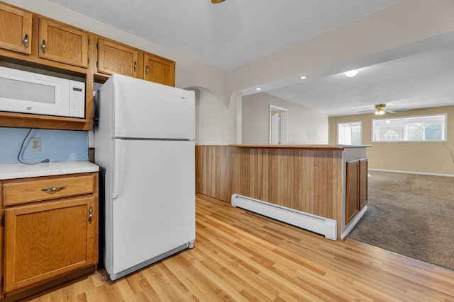 kitchen featuring white appliances, a baseboard radiator, light hardwood / wood-style floors, and ceiling fan