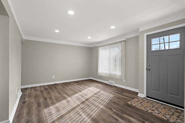 entrance foyer with ornamental molding and dark hardwood / wood-style floors