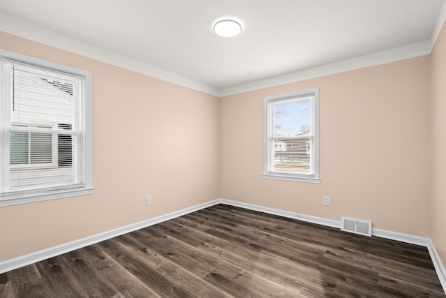 spare room featuring dark hardwood / wood-style flooring and ornamental molding