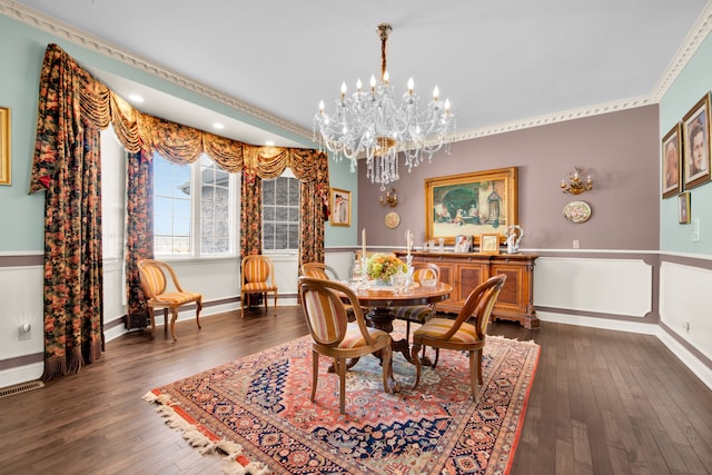 dining space with ornamental molding, dark wood-type flooring, and a chandelier