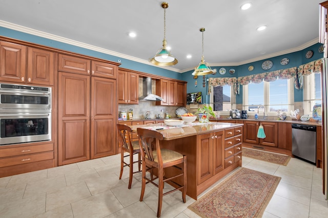 kitchen with a kitchen island, appliances with stainless steel finishes, a kitchen breakfast bar, light stone countertops, and wall chimney exhaust hood