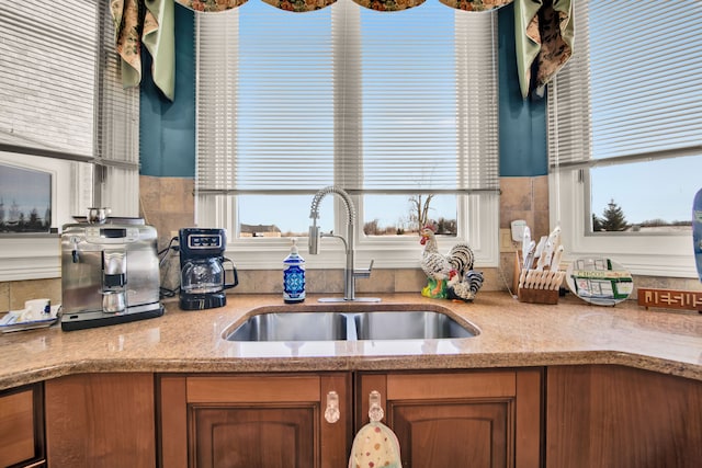 kitchen featuring light stone countertops, sink, and a wealth of natural light