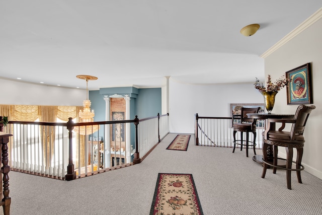 corridor with ornamental molding, carpet flooring, and a notable chandelier